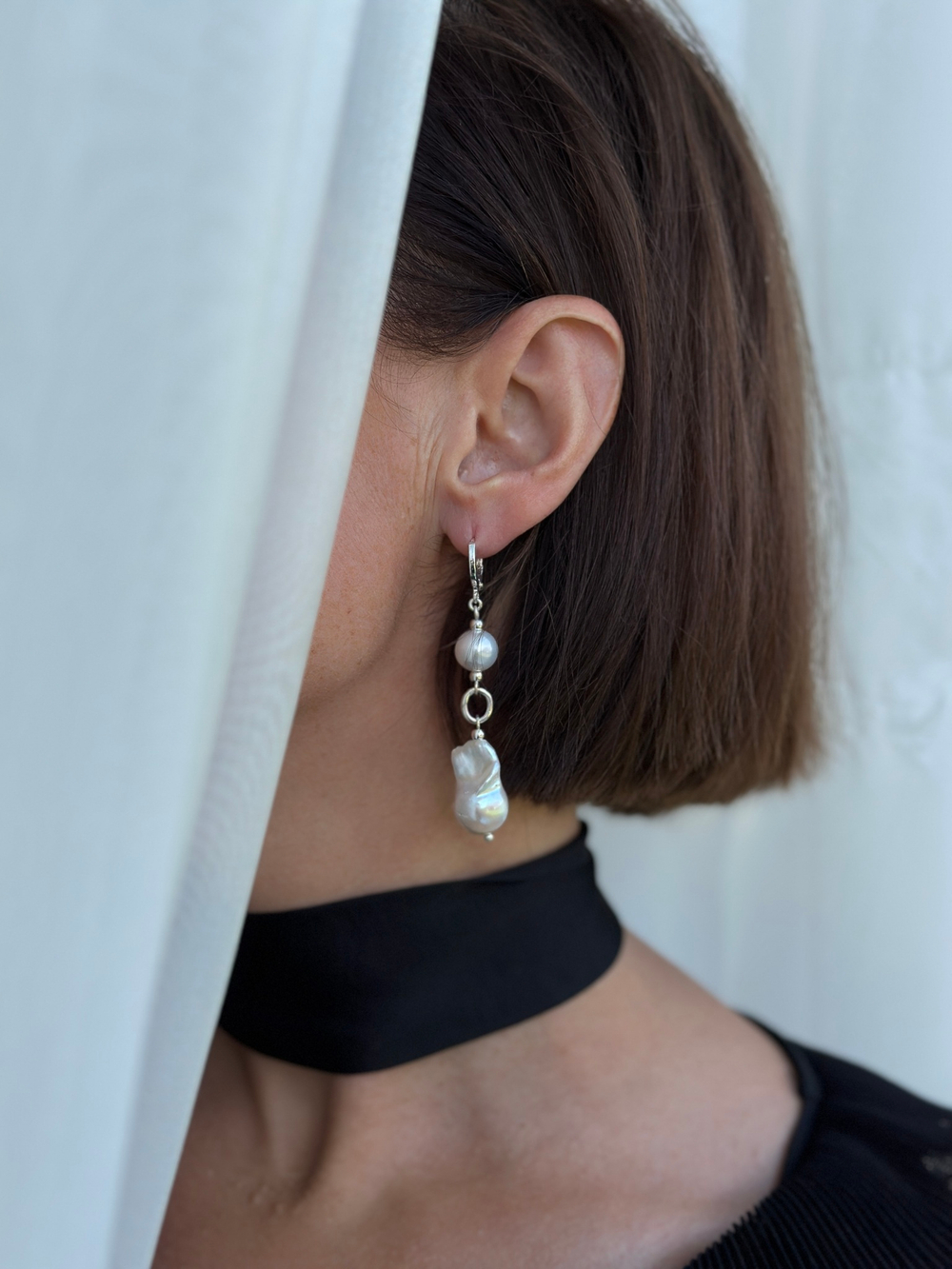 Серьги с двумя жемчужинами: круглой и барочной. Замок левербек. Оттенок светлое серебро.