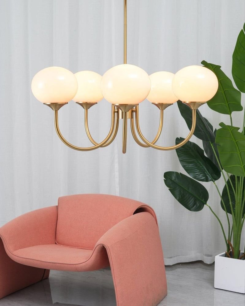 Элегантная люстра с глянцевыми розовыми плафонами и изящным золотым каркасом.