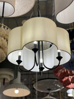 Элегантная люстра с текстильным абажуром в светлом оттенке и черным металлическим основанием.