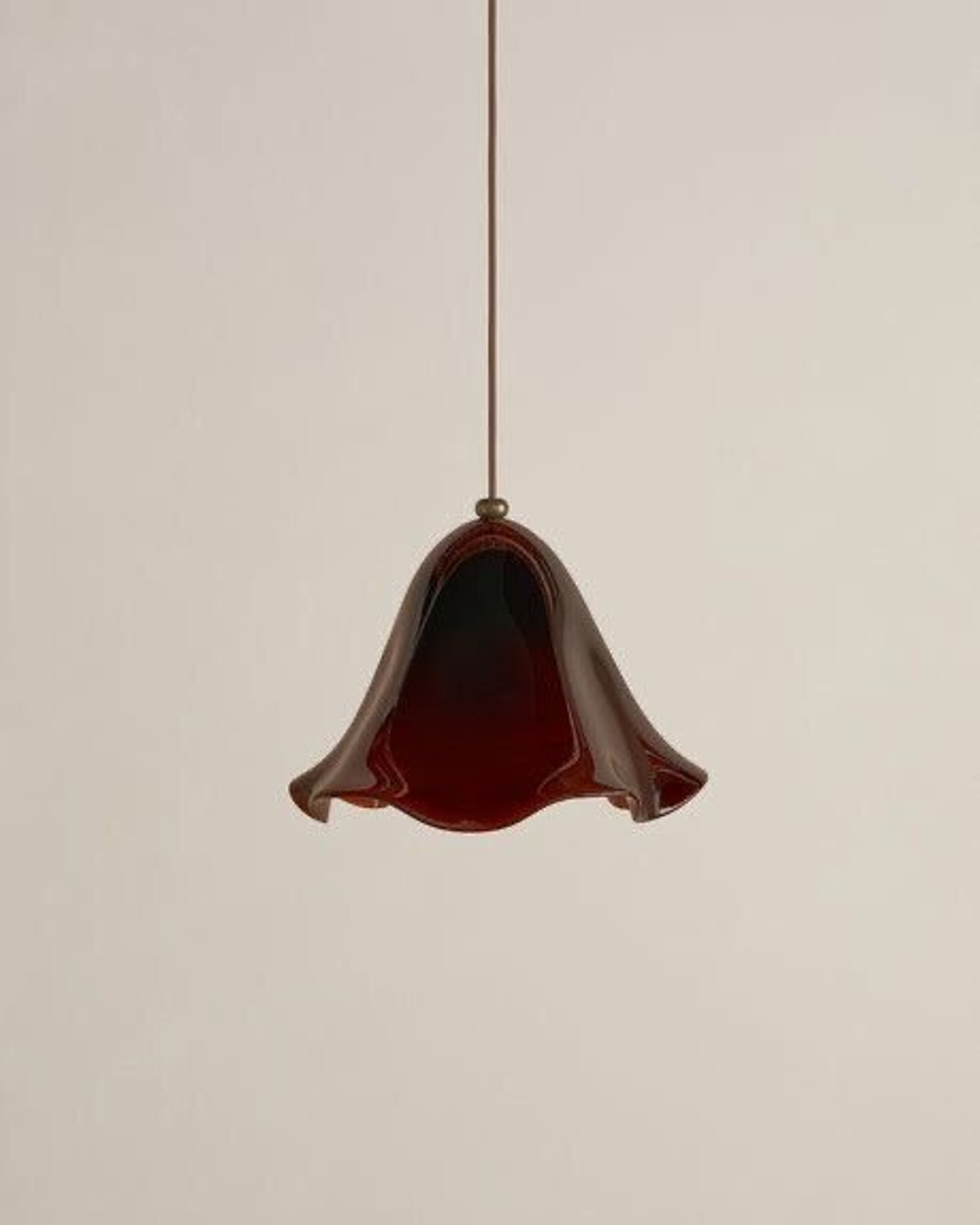 Эти подвесные светильники выполнены из гладкого, глянцевого стекла и имеют мягкую, волнообразную форму, напоминающую расплавленную ткань.