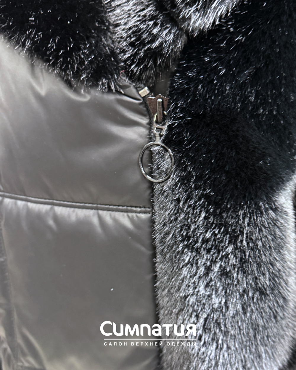 Теплое пальто черного цвета и отделкой из эко меха норки