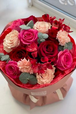 Композиция из красных и розовых роз, кремовых диантусов и веточек эвкалипта