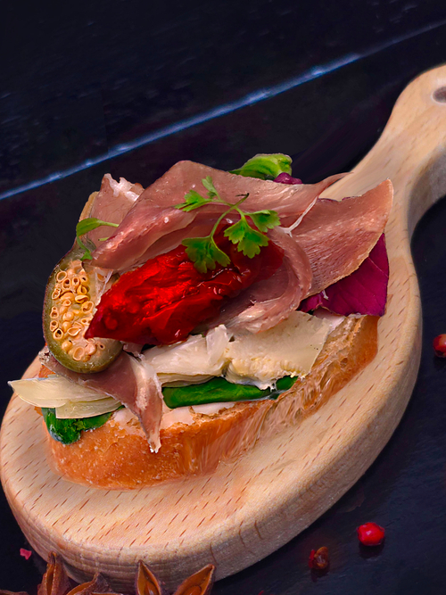 Брускетт с пармской ветчиной, каперсами, вяленным томатом и артишоком