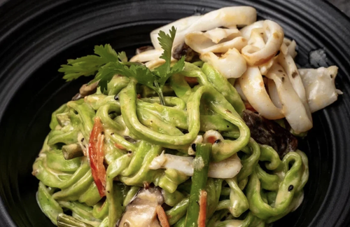 Вок с кальмаром и овощами на зелёном тесте в сырном соусе