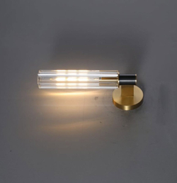 Элегантное настенное бра с вытянутым хрустальным плафоном и металлическим корпусом в тёплом золотом оттенке.