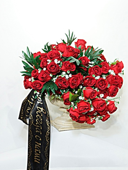 Траурный букет красных роз в античной вазе