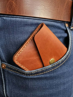 Изображение картхолдера из натуральной кожи с кнопкой коричнево-рыжего цвета в кармане