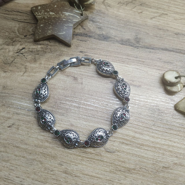 Браслет Vogue Капля стразы графитовые зеленые красные металл серебристый на красном бархате