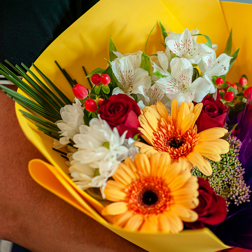 Яркий букет в желтой цветовой гамме с герберами и красными розами