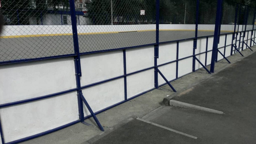 Хоккейный корт обшитый стеклопластиковыми листами, сетка рабица за воротами