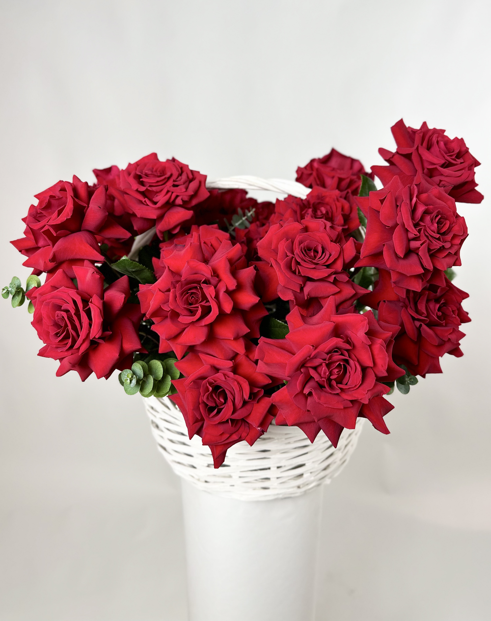 Bouquet of 25 red French Bordeaux roses in a basket