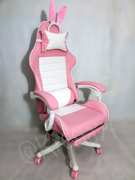 Розовое геймерское кресло с подножкой.