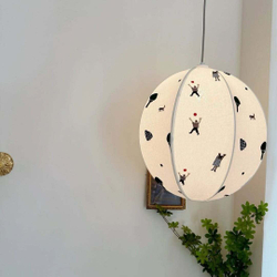 Нежный подвесной светильник в виде круглого абажура с минималистичными рисунками людей и деревьев.