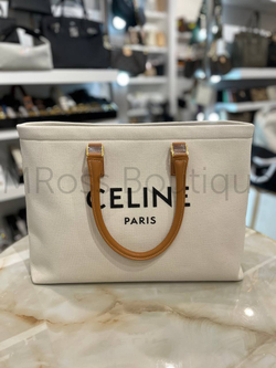 Celine Cabas Drawstring premium women's shopper bag crafted from canvas with brown calfskin inserts. Discreet beach bag with black Celine lettering on the front, brown leather handles and an inside zip pocket.