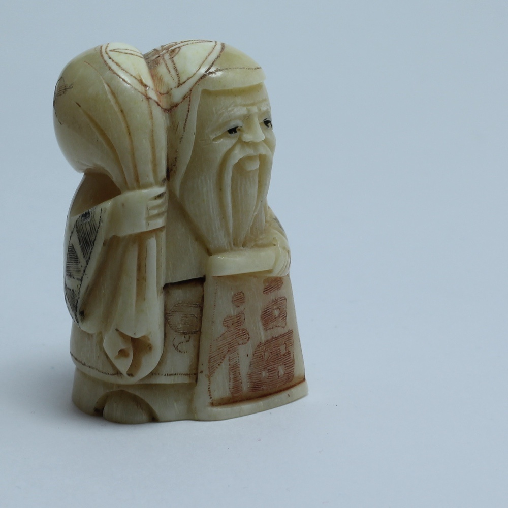 Нэцкэ Фукурокудзю с мешком риса и иероглифом "Счастье"