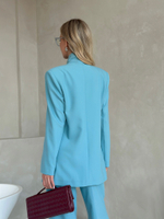 Костюм брючный в бирюзовом цвете с брошью-цветком