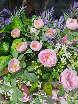 Розы лиловые с зеленью в длинном кашпо ротанг