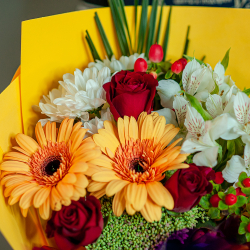 Яркий букет в желтой цветовой гамме с герберами и красными розами