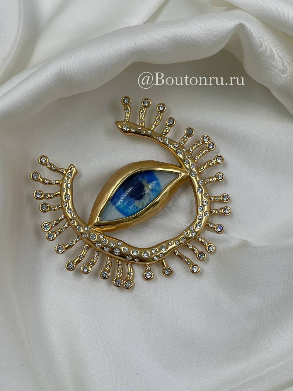 Брошь Скиап. золотистая в форме глаза с подковой из ресниц со стразами